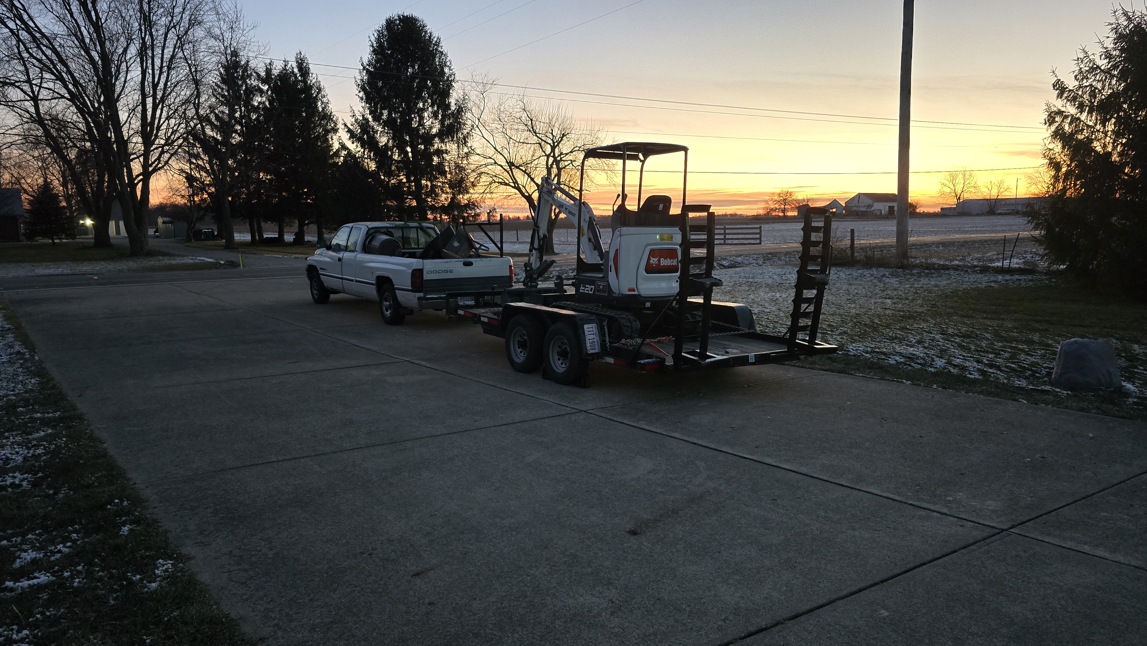 Excavator on trailer at sunset